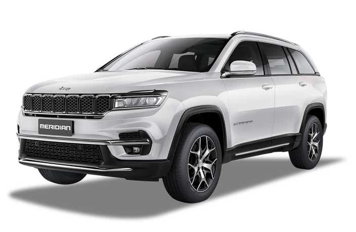 front three-quarter view of a Pearl White Jeep Meridian
