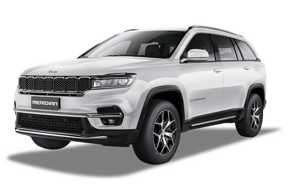 front three-quarter view of a Pearl White Jeep Meridian