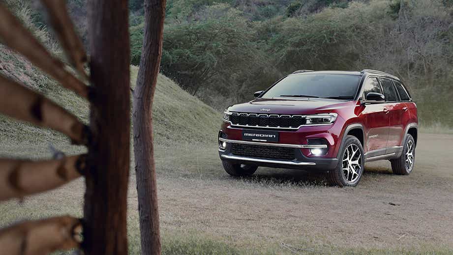 front three-quarter of a Velvet Red Jeep Meridian