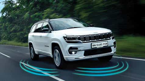 front three-quarter view of a Pearl White Jeep Meridian