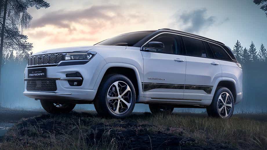 front three-quarter view of a Pearl White Jeep Meridian