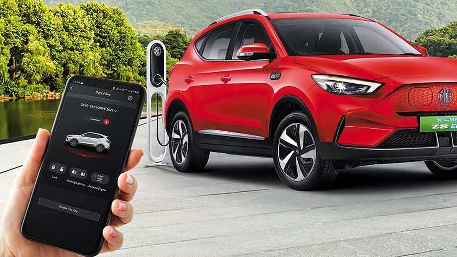front and side view of a Glaze Red MG ZS EV at a charging station
