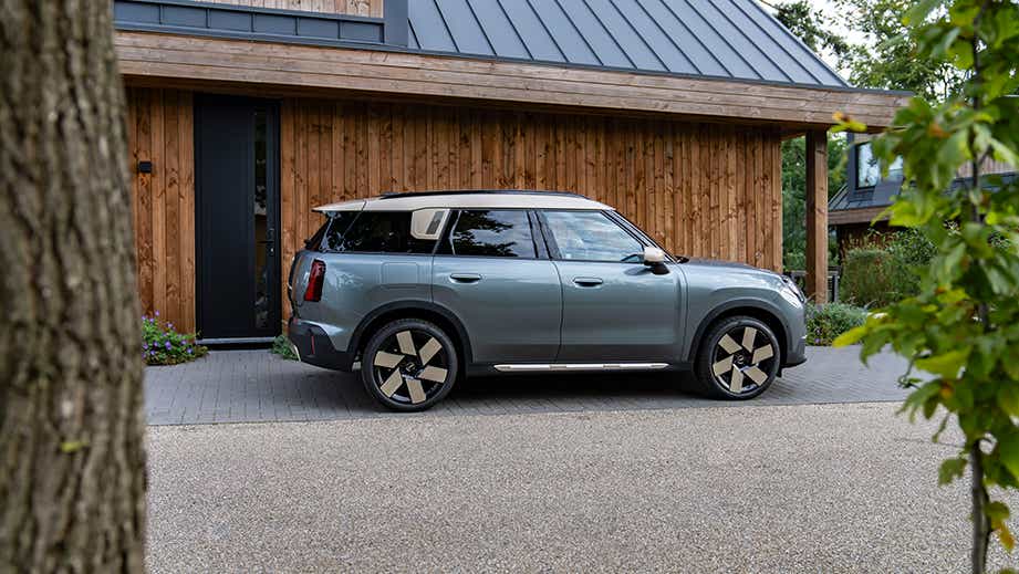 side view of a Mini Cooper Countryman EV parked by a house