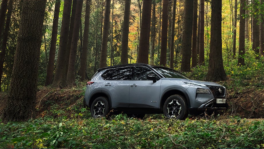 side view of a Nissan X-Trail in a forest