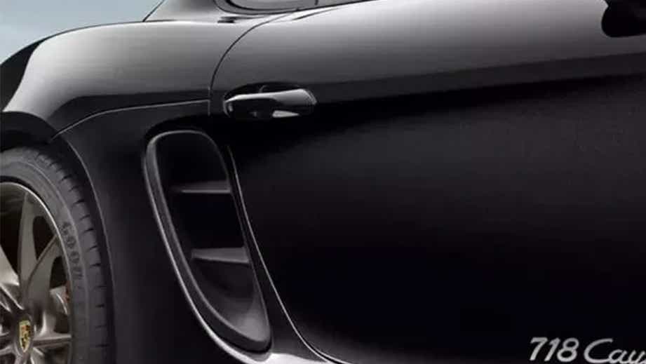 Close-up of the rear fender and side vent of a Jet Black Metallic Porsche 718