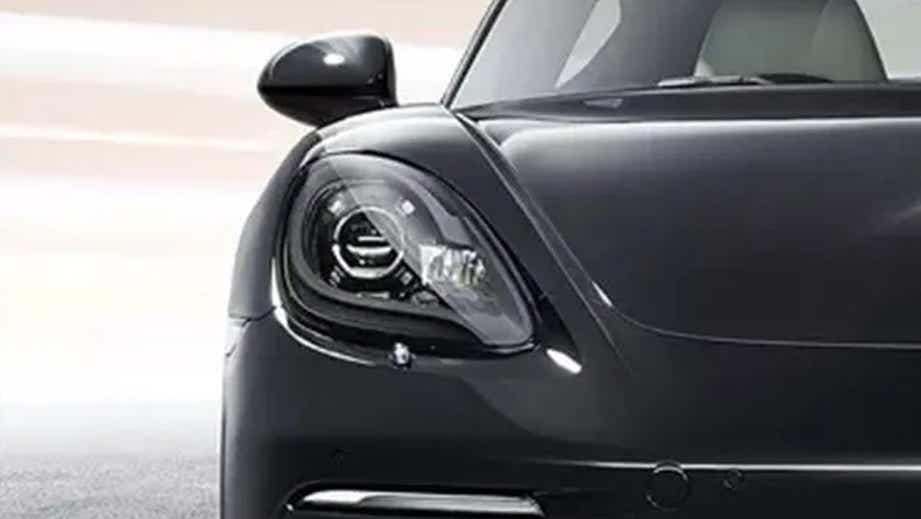 Headlight close-up of a Jet Black Metallic Porsche 718