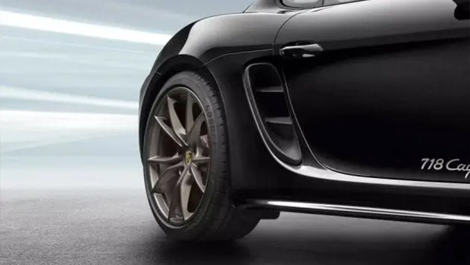 rear wheel and side view of a Jet Black Metallic Porsche 718
