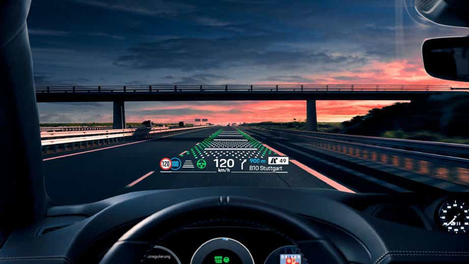 driver's view of a Porsche Macan EV digital dashboard and HUD display on open road
