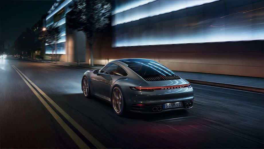 rear three-quarter of a Porsche 911 driving at night