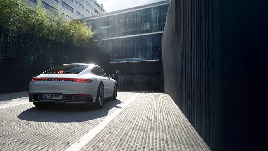 Rear view of a Porsche 911 driving up a ramp