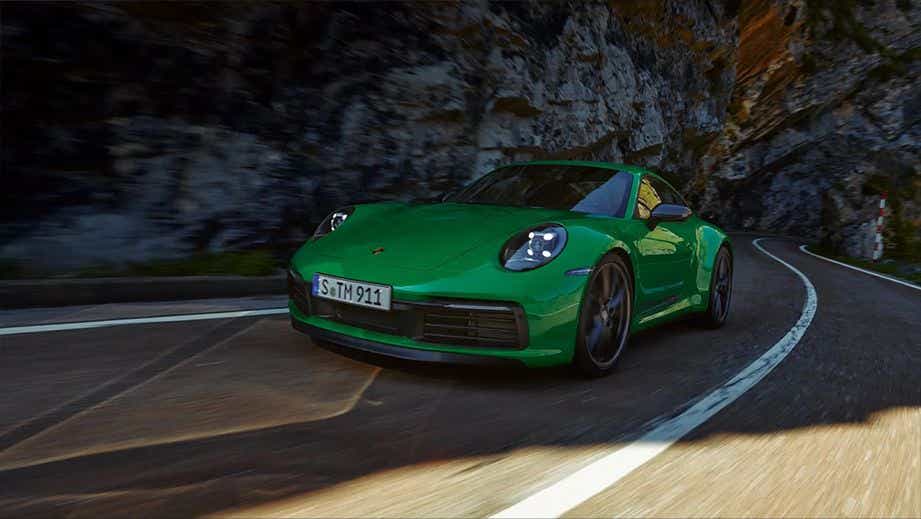 front three-quarter view of a Porsche 911 driving on a mountain road