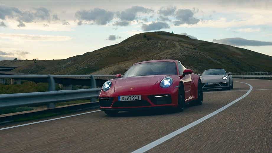 front view of a Porsche 911 driving on a scenic road