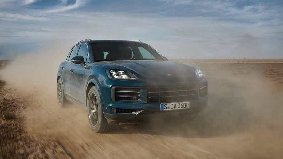 front view of a Porsche Cayenne driving on a dirt road