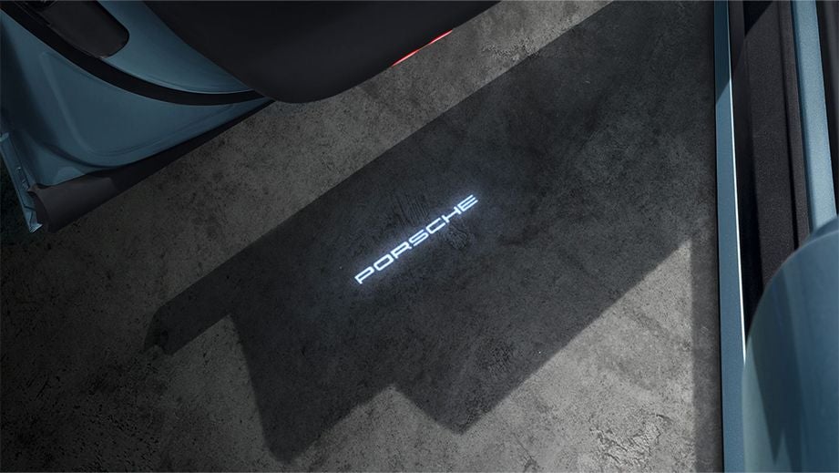 Puddle light projection from the open door of a Porsche Taycan