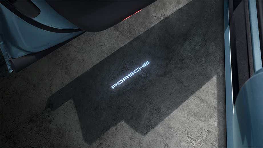 Puddle light projection from the open door of a Porsche Taycan
