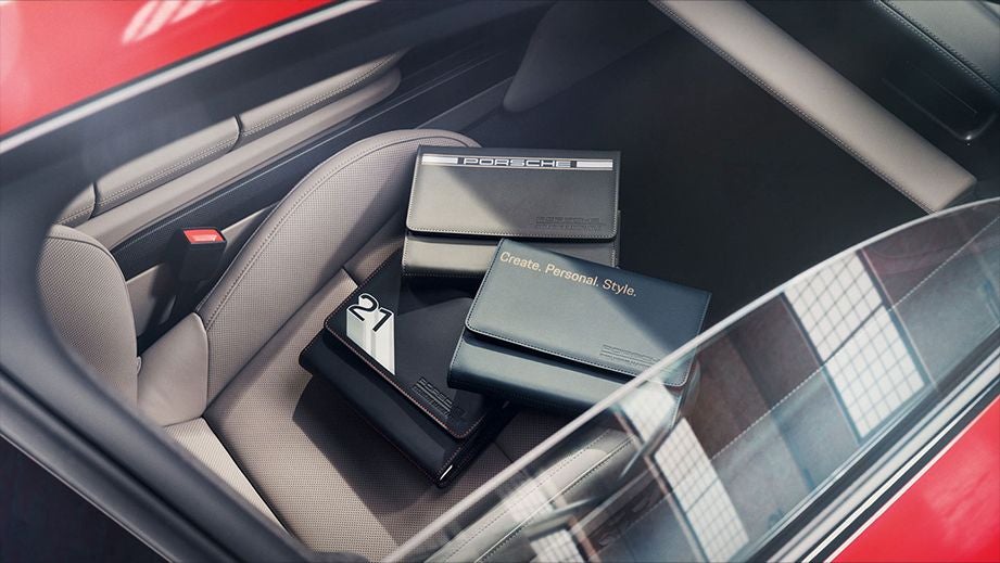 Interior seat view of a Porsche Taycan with booklets on seat