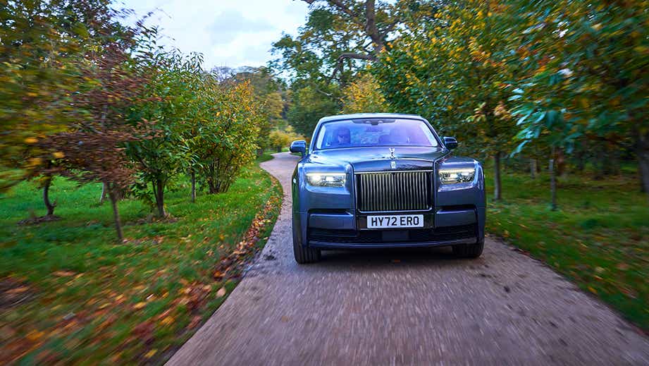 front view of a Rolls-Royce Phantom driving on a park road