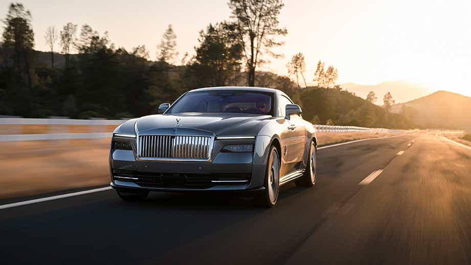 front view of a Rolls-Royce Spectre driving on an open road