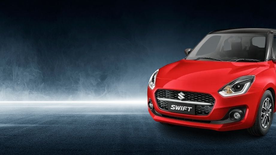 Front three-quarter view of a Solid Fire Red with Pearl midnight black roof Maruti Suzuki Swift 2021 - 2023