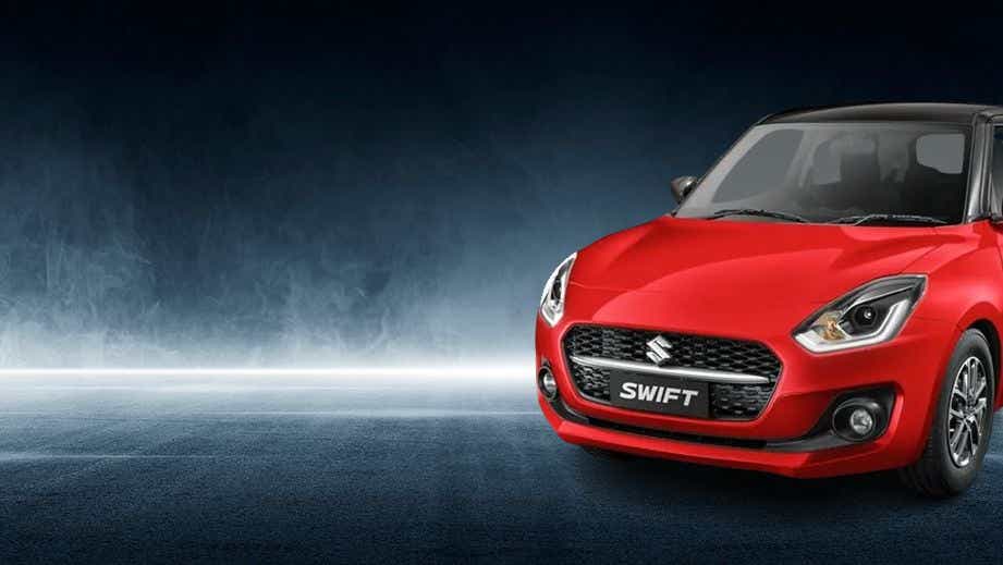 Front three-quarter view of a Solid Fire Red with Pearl midnight black roof Maruti Suzuki Swift 2021 - 2023