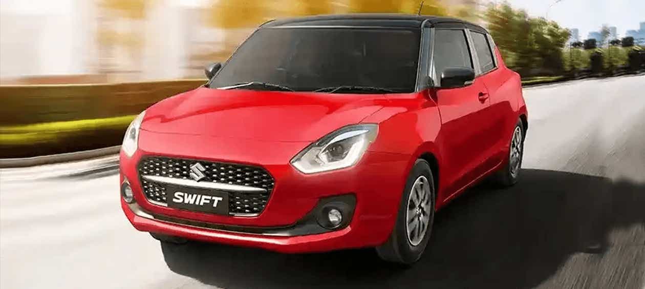front three-quarter of a Solid Fire Red with Pearl midnight black roof Maruti Suzuki Swift 2021 - 2023