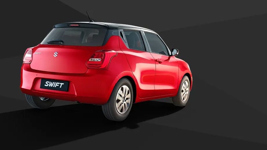 rear three-quarter of a Solid Fire Red with Pearl midnight black roof Maruti Suzuki Swift 2021 - 2023