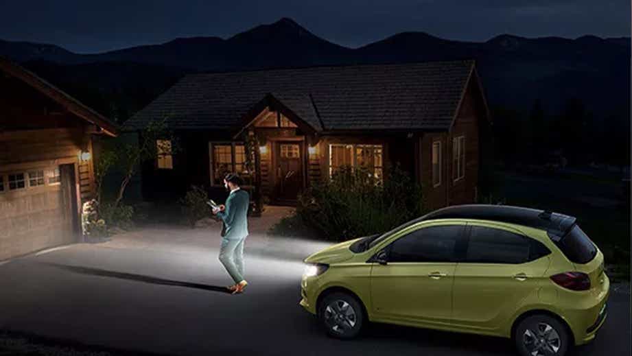 side view of a Chill Lime With Dual Tone Tata Tiago EV parked outside a house at night