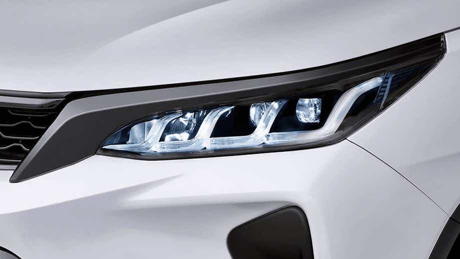 headlight close-up of a Platinum White Pearl Toyota Fortuner Legender