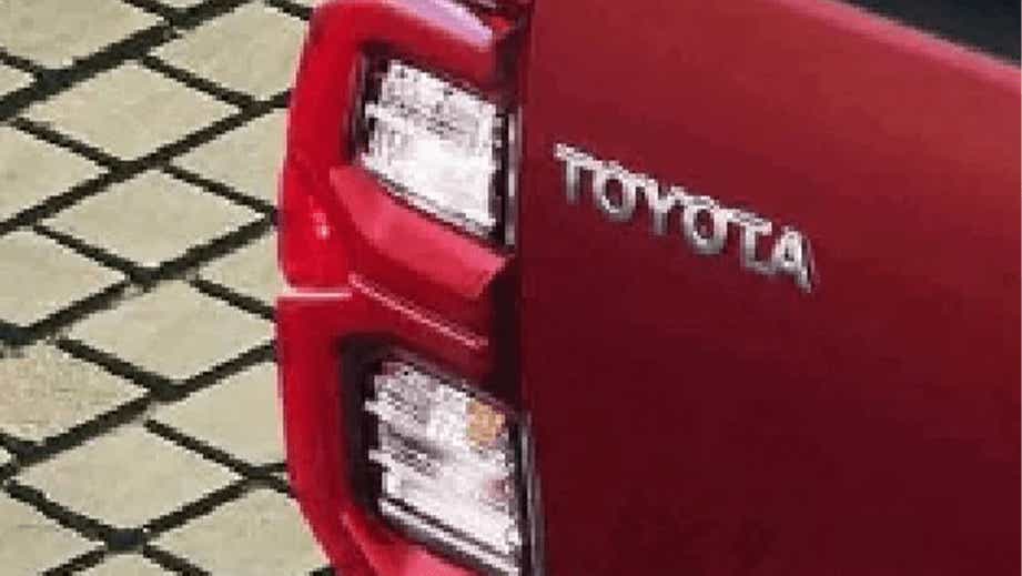 Rear tail light and badge of a Emotional Red Toyota Hilux