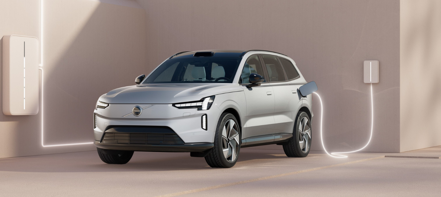 front three-quarter view of a Crystal White Volvo EX90 charging