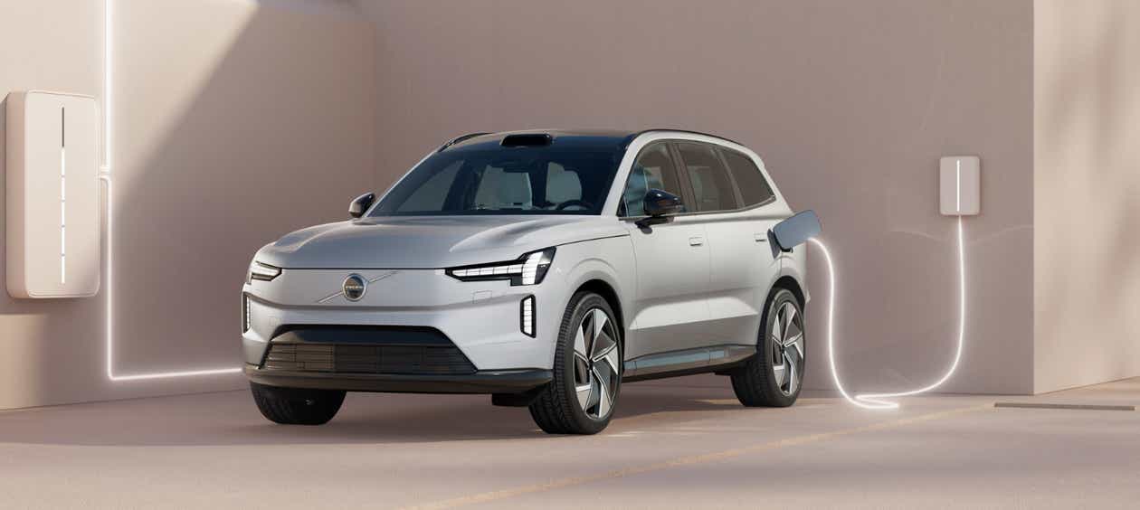 front three-quarter view of a Crystal White Volvo EX90 charging