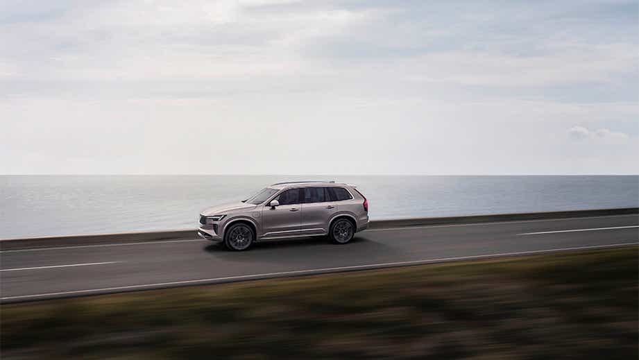 side view of a Volvo XC90 driving on a coastal road