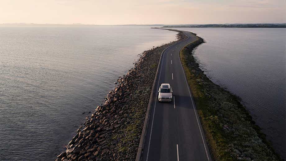 aerial view of a Volvo XC90 driving on a coastal road