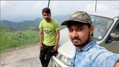 Front view of a Maruti Suzuki Alto near a scenic hillside