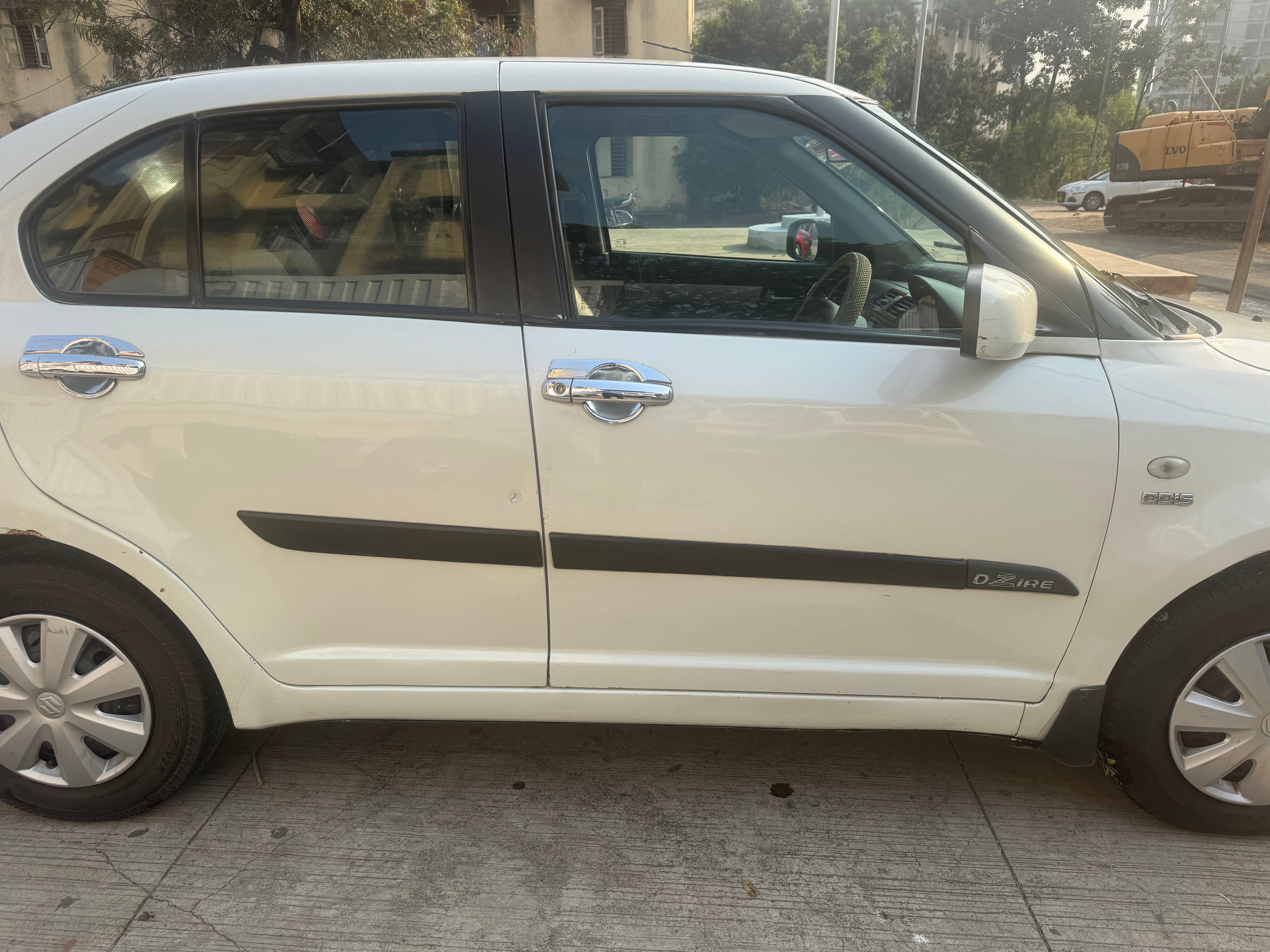 side view of a Pearl Metallic Arctic White Maruti Suzuki Dzire Tour
