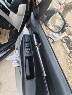 Front driver-side door controls and handle of a Kia Sonet