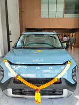 front view of a Kia Syros at a showroom entrance