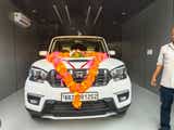 front view of a Everest White Mahindra Scorpio Classic decorated with flowers