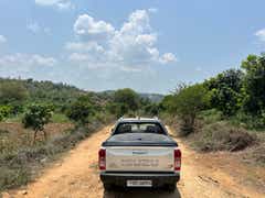 rear view of an Isuzu V-Cross on a dirt road