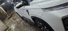 Side view of a Candy White MG Hector Plus at a car wash