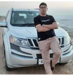 Front view of a Mahindra XUV700 with a person leaning on it