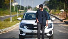 Front view of a Kia Seltos with a person standing in front