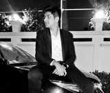 Front view of a Toyota Fortuner with a person sitting on the hood