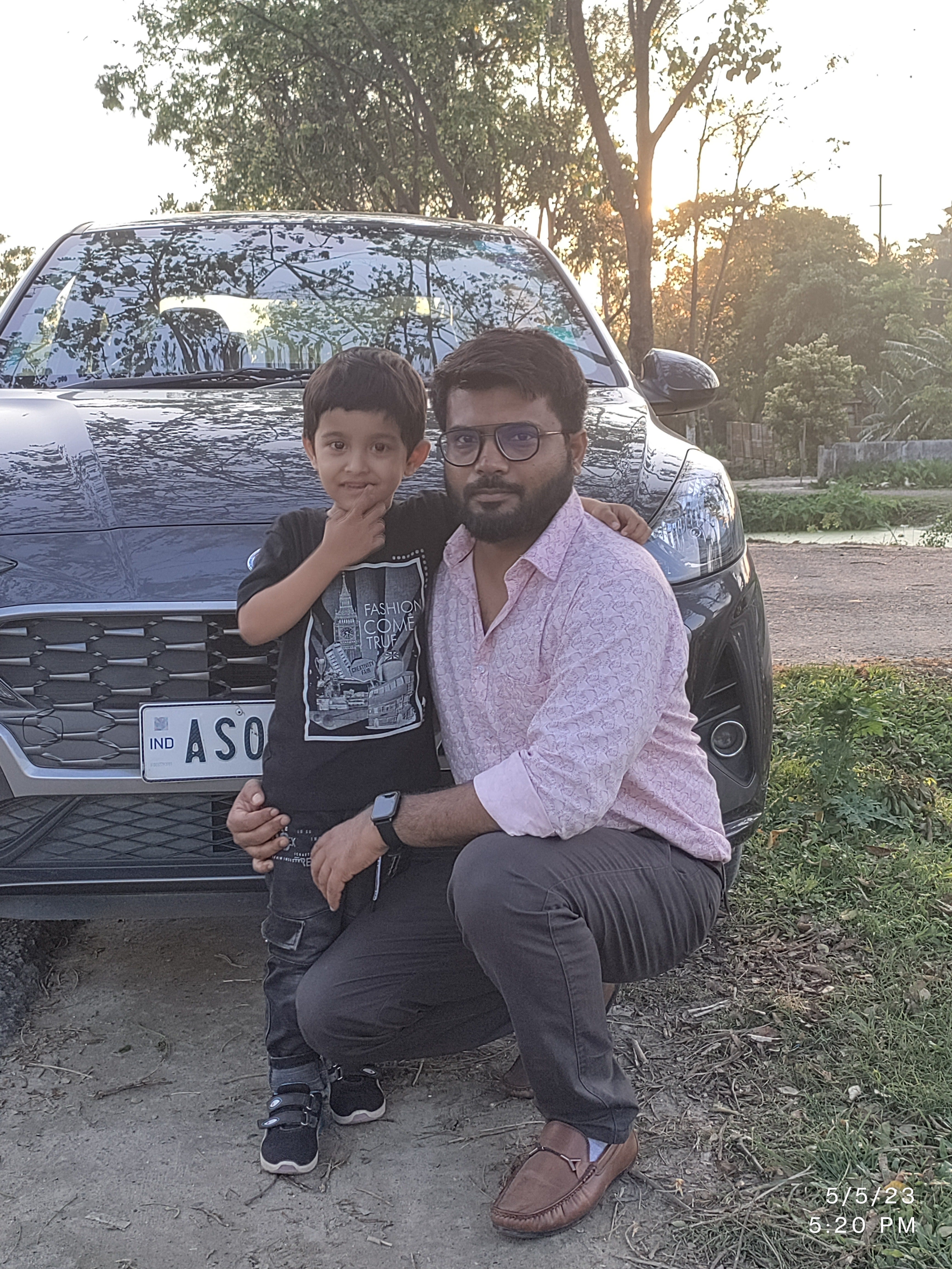 Front view of a Hyundai Aura car with two people posing