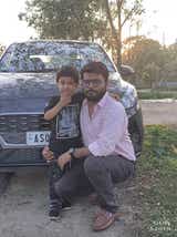 Front view of a Hyundai Aura car with two people posing