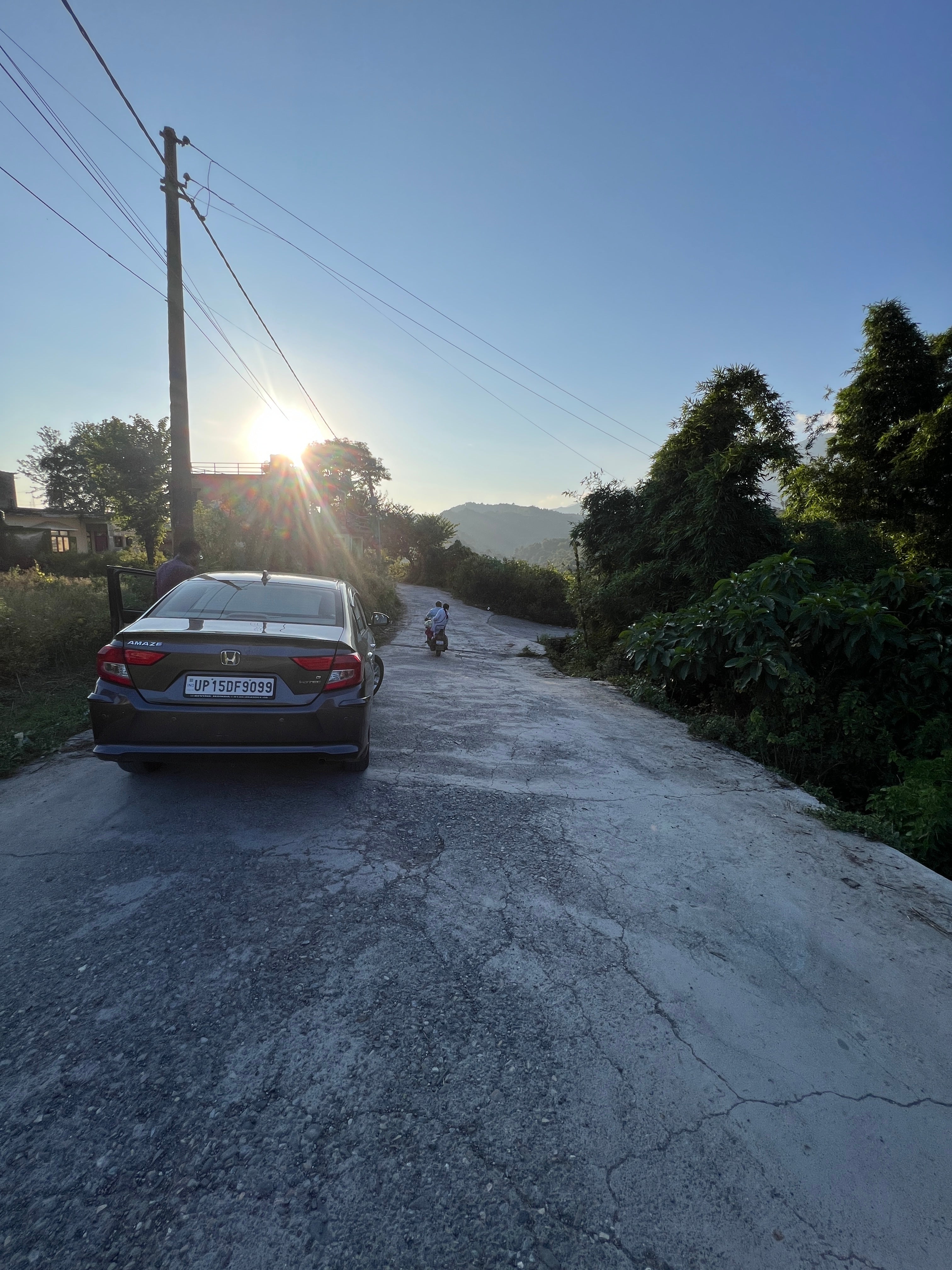 Rear view of a Honda Amaze 2022-2023 parked on a hilly road
