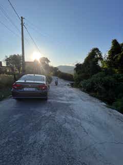 Rear view of a Honda Amaze 2022-2023 parked on a hilly road