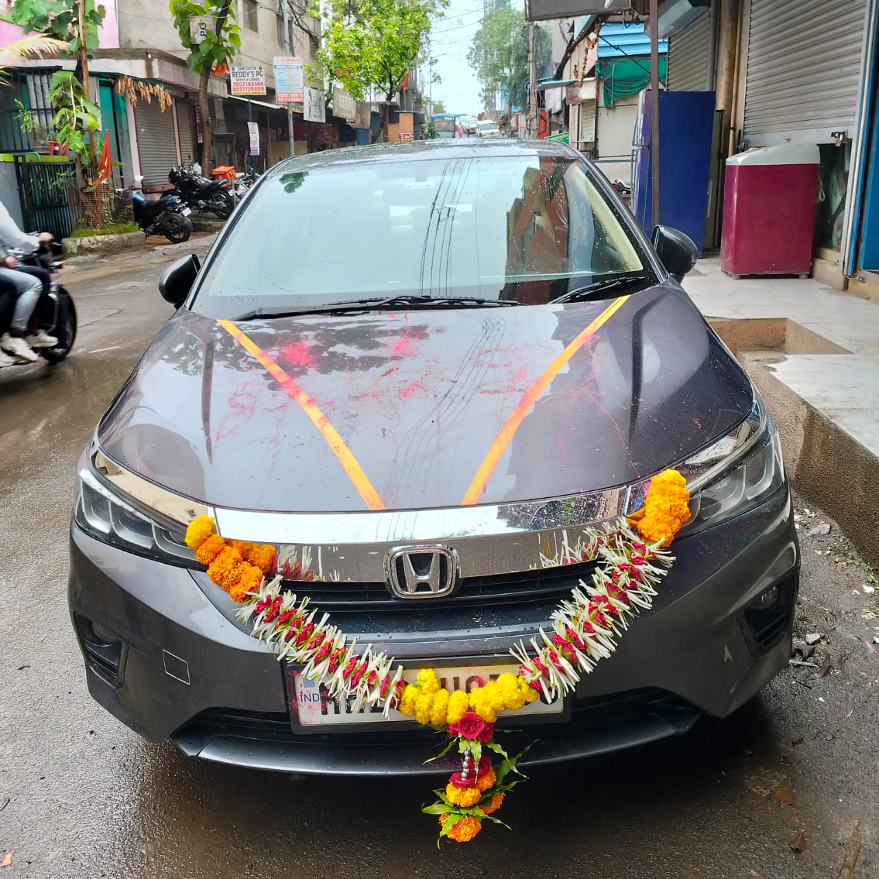 front view of a Honda City decorated with flowers on a street