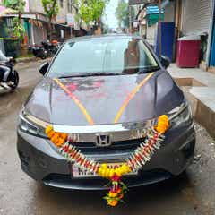 front view of a Honda City decorated with flowers on a street