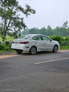 rear three-quarter view of a Honda City parked on a rural roadside